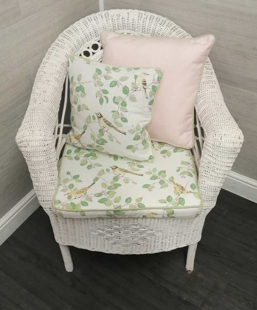 lovely cushioned white wicker armchair