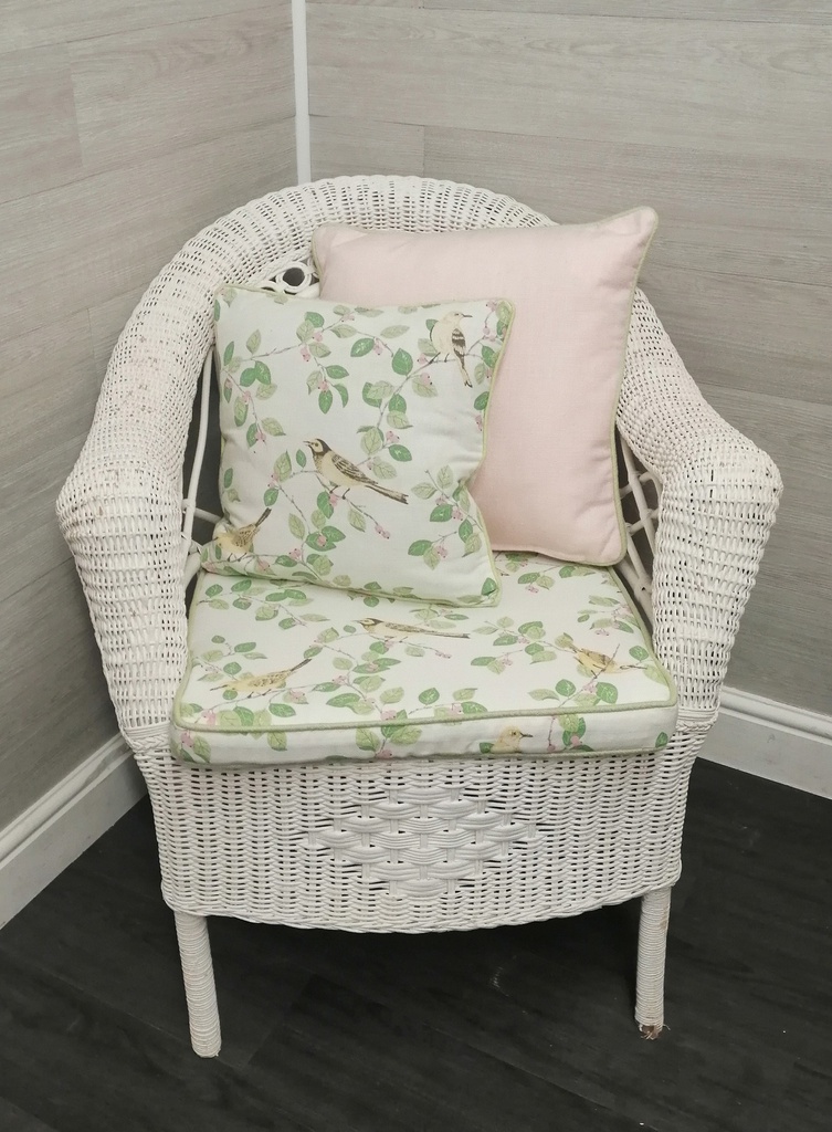 lovely cushioned white wicker armchair